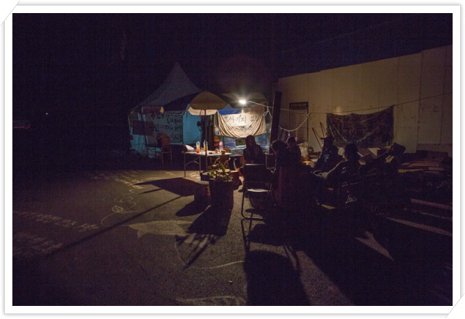 꾸미기_14. 밤과 시위천막을 지키는 군관사 공사장 앞 마을사람들.jpg